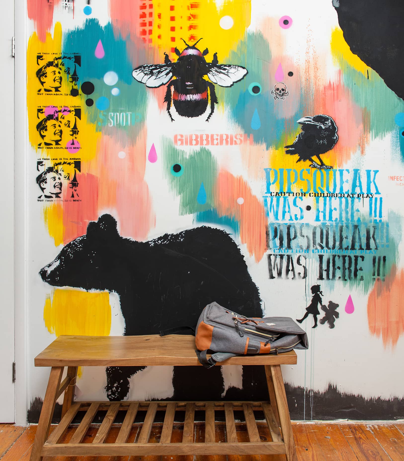 Backpack resting on top of sitting bench against a graffiti-painted wall | Think Twice studio